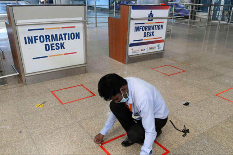 A worker marks squares on the ground at the Rajiv Gandhi International Airport in Hyderabad.