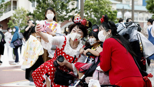 Visitors sport Disney-themed face masks. Kyodo News/AP