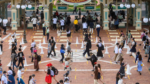 Guests wait in a socially-distant line to get into Tokyo Disneyland on opening day. Philip Fong/AFP/Getty Images