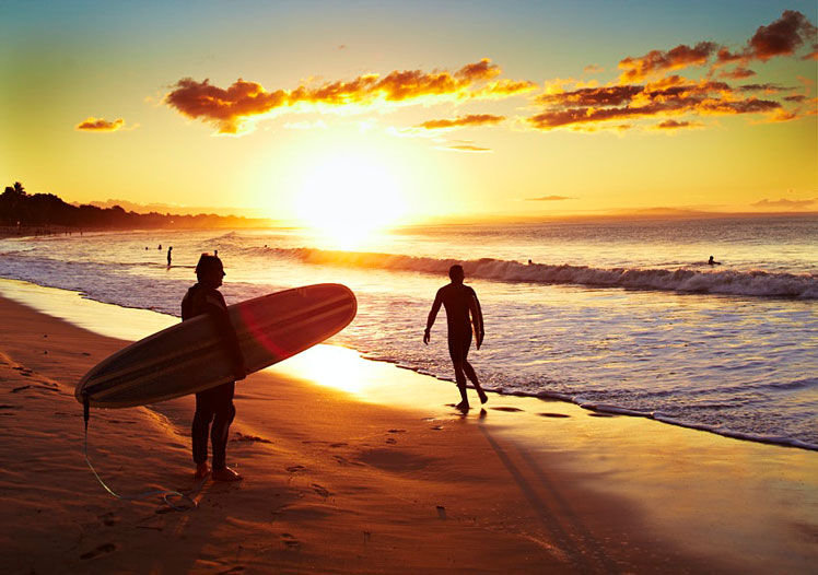 Surfer on beach at sunset, Noosa Heads. ©Matt Munro/Lonely Planet